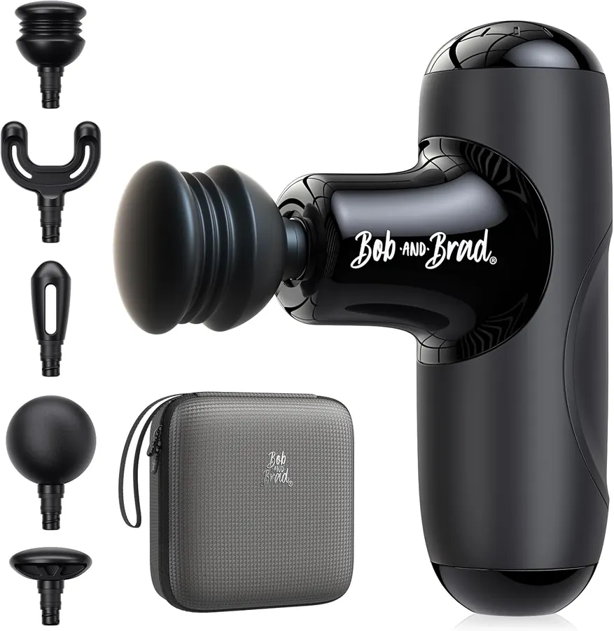 BOB AND BRAD Q2 Mini massage gun held in one hand next to a foam roller on a gym floor